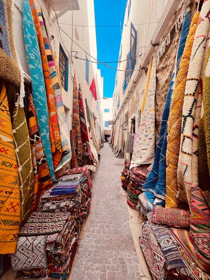 Colorful traditional rugs in a bustling Moroccan souk, perfect for travelers.