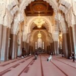 Ornate interior of Hassan II Mosque with chandeliers and arches in Casablanca.