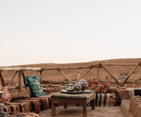 Charming rooftop terrace with Moroccan decor in Fes at sunset, featuring traditional seating and a scenic view.