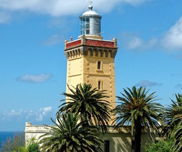 Stunning view of Cape Spartel Lighthouse amidst lush palm trees in Tangier.