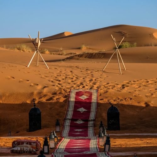 Explore the stunning sunset in Merzouga, Morocco with a vibrant pathway through the dunes.
